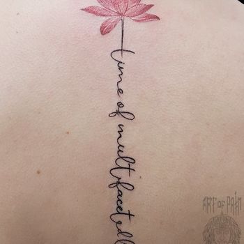 Татуировка женская графика на спине надпись и лотос