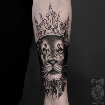 Татуировка женская black&grey на предплечье лев с короной