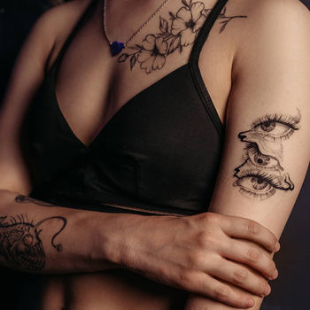 Татуировка женская графика на плече, предплечье и ключице глаза, рыба, цветы