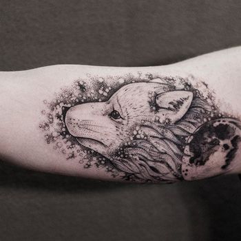 Татуировка мужская дотворк на бицепсе волчонок