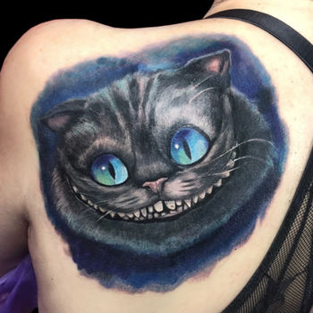 Татуировка женская фентези на лопатке чеширский кот