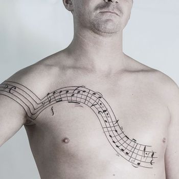 Татуировка мужская графика на груди ноты