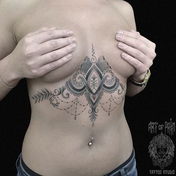 Татуировка женская графика на груди узор с подвесками