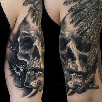 Татуировка мужская хоррор на бицепсе череп, перья и пули