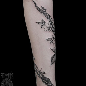 Татуировка женская графика на предплечье пятнистая змея в цветах