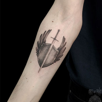 Татуировка женская графика на предплечье щит, меч и крылья