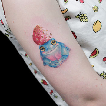 Татуировка женская акварель на плече лягушка с клубникой