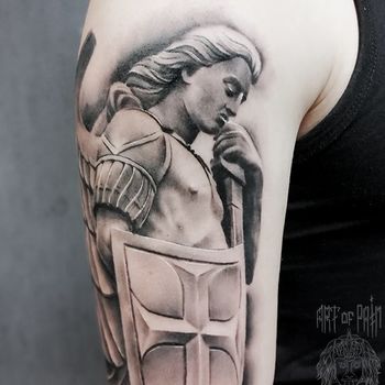Татуировка мужская black&grey на плече статуя ангела-хранителя на холме Tepeyac