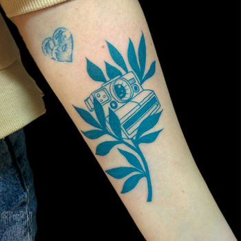 Татуировка женская графика на предплечье растение и фотоаппарат