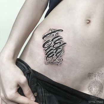 Татуировка женская каллиграфия на животе надпись