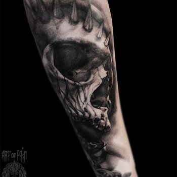 Татуировка мужская хоррор на предплечье череп с шипами