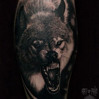 Татуировка мужская реализм на голени оскал волка