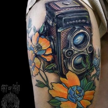 Татуировка женская нью-скул на бедре фотоаппарат и цветы