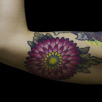 Татуировка женская олд скул на бицепсе цветы