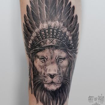 Татуировка мужская графика на предплечье лев с индейским роучем