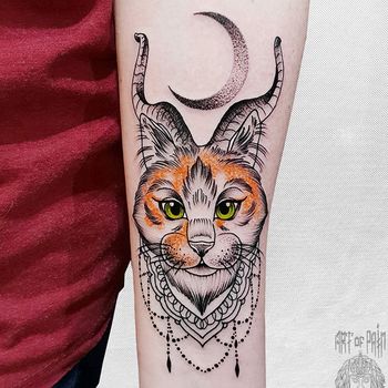 Татуировка женская графика на предплечье кот с рогами