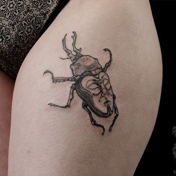 Татуировка женская графика на бедре жук и лицо