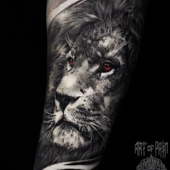 Татуировка мужская реализм на предплечье лев с красными глазами